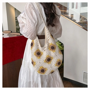Détail d'un sac à bandoulière en crochet blanc avec motif tournesol au style bohème