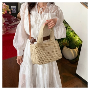 Detailed close-up of a woven beige handbag featuring a distinctive crochet triangle pattern