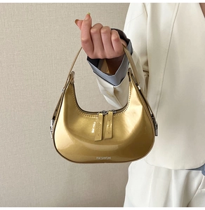 Détail du sac demi-lune doré avec finition métallique et logo fashion imprimé sur le cuir