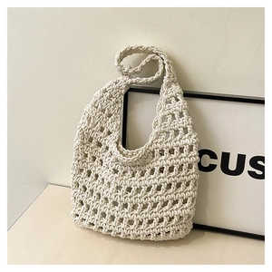 Close-up of cream woven mesh handbag showing intricate hollow crochet texture