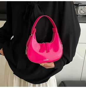 Gros plan d'un sac hobo en cuir verni rose vif avec texte Fashion blanc imprimé