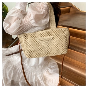 Detail of hand-woven straw shoulder bag with iconic triangle knit and brown leather strap