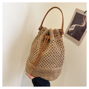 Détails rapprochés du sac seau tissé avec cordon en cuir et œillets métalliques de finition