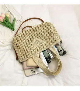 Top view of spacious woven crossbody bag interior filled with daily essentials and strap