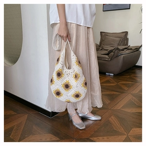 Gros plan détaillé du sac en paille au crochet avec motif floral de tournesol fait à la main