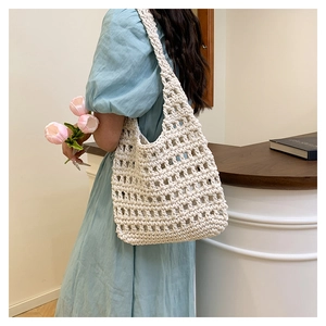Detail of cream woven handbag showing thick rope crochet texture and mesh hollow pattern