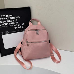 Pink minimalist commuter backpack with multi-pocket design on a clean white surface