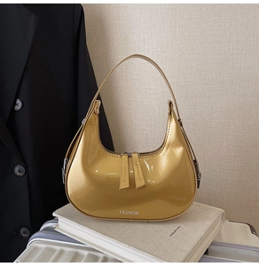 Vue détaillée du sac hobo croissant doré brillant avec fermeture éclair et logo fashion