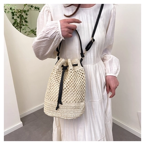 Détail du sac seau tissé avec cordon en cuir noir et bandoulière réglable pratique