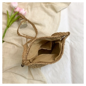 Detail view of woven straw bag interior showing zipper closure and fabric lining with pocket