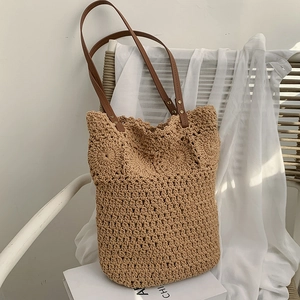 Handwoven straw tote bag with floral patterns and brown leather straps for summer vacations