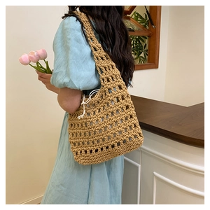 Detailed side view of woven shoulder bag with hollow mesh design and inner drawstring pouch