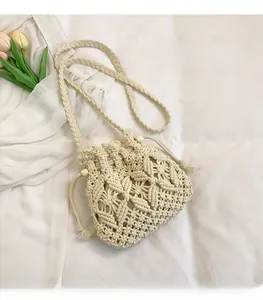 Detail of hand-woven cream bucket bag featuring hollow diamond patterns and wooden beads