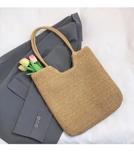 Close-up of a beige hand-woven tote bag displayed on a grey blazer with tulips