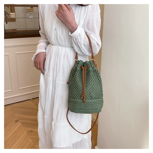 Détail du sac seau tressé vert avec maille ajourée et cordon de serrage en cuir brun