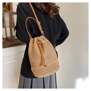 Détail du sac seau tissé avec motif en maille aérée et bandoulière en cuir marron