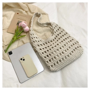Close-up of off-white hand-woven crochet tote bag with a wide strap and mesh design
