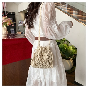 Detail of bohemian cream macrame bucket bag with diamond weave and drawstring closure