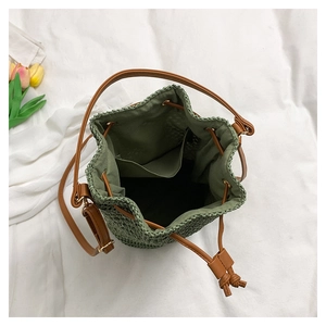 Détail de l'intérieur d'un sac seau tissé avec doublure olive et cordon en cuir