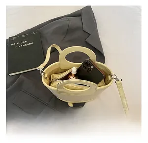Top view of cream canvas shell bag interior showing storage for phone and cosmetics
