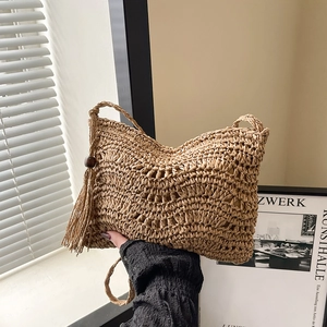 Handmade woven straw crossbody bag with tassels and wave texture for a boho summer style
