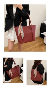 Detail view of large dark red pebble grain leather tote bag with a decorative silk scarf