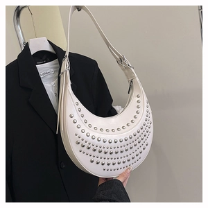 Detail of white moon-shaped hobo bag with silver rivets and elegant tassel zipper