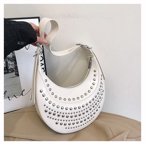 Macro detail of white crescent hobo bag with silver metallic studs and smooth leather texture
