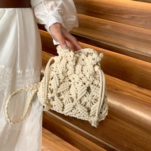 Handmade woven crossbody bucket bag with bohemian geometric pattern and wood bead drawstring