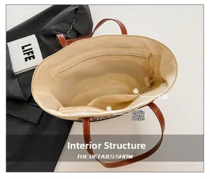 Macro shot showing the spacious main compartment and phone pocket of the straw tote bag