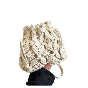 Handmade cream macramé bucket bag with floral weave patterns and decorative wooden beads