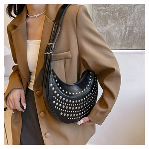 Detail of black crescent shoulder bag with silver rivet studs on textured leather