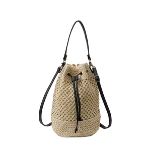 Sac seau minimaliste en paille tressée avec lanières en cuir noir et cordon de serrage