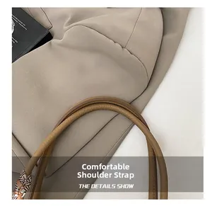 Detail of beige tote bag with brown leather shoulder strap and printed silk scarf wrap