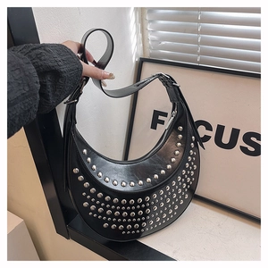 Close-up of black studded hobo bag featuring silver rivets and glossy faux leather texture