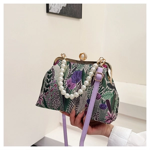 Close-up of vintage embroidery purse featuring floral patterns and a large pearl clasp