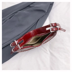 Top view of burgundy patent leather bag with silver studs and beige fabric lining