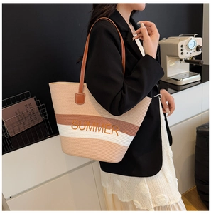 Detail of striped woven tote bag with SUMMER embroidery and slim leather handles