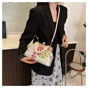 Detailed view of floral crossbody bag with large pearl handle and pink shoulder strap