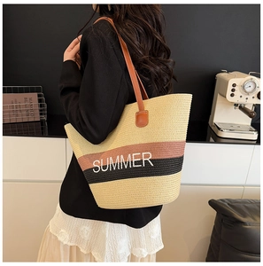 Detail of summer straw tote with tricolor stripes and brown leather shoulder strap