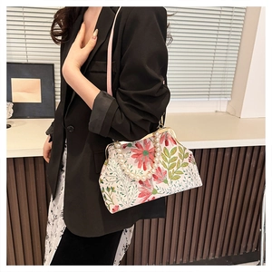 Detail of floral embroidery and pearl handle on a vintage evening shoulder bag