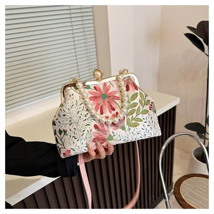 Detail of vintage frame bag with floral embroidery and elegant pearl bead handle