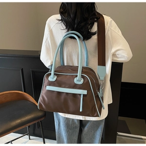 Detail view of large canvas tote bag with sky blue leather trim and wide shoulder strap