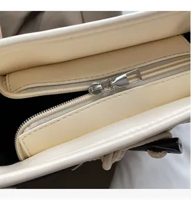 Detailed macro view of the smooth silver zipper and interior lining of the cream canvas bag
