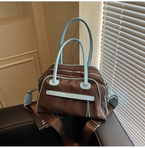 Close-up of contrast color tote bag with sky blue handles and brown nylon body