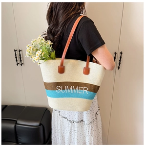 Detail of summer straw tote bag featuring blue stripes and white Summer embroidery