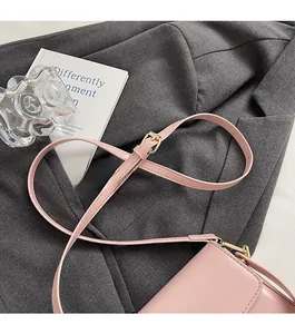 Détail de la bandoulière réglable en similicuir rose et boucle en métal doré du sac