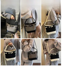 Detail of canvas bucket bags with leather trim in black, white, and grey contrast colors