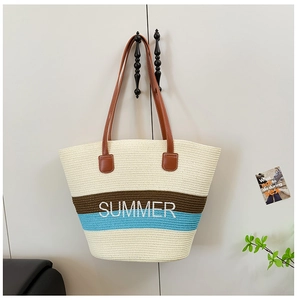 Detail of summer straw tote bag with blue stripes and white embroidered SUMMER text