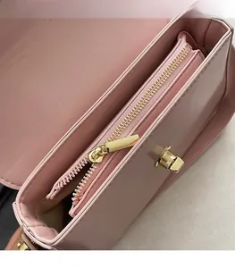 Détails de l'intérieur d'un sac rose avec fermeture éclair dorée et fermoir rotatif